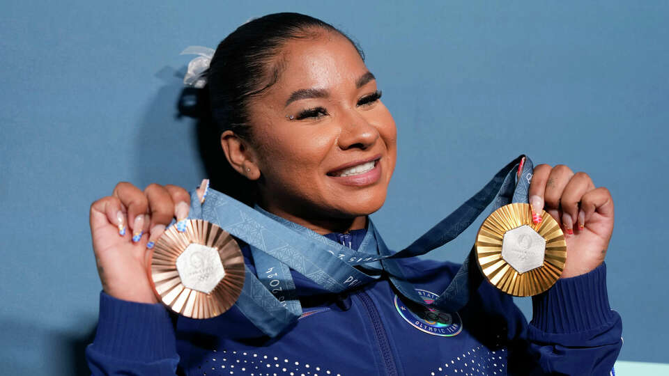 Jordan Chiles, of the United States, holds up her medals after the women's artistic gymnastics individual apparatus finals Bercy Arena at the 2024 Summer Olympics, Aug. 5, 2024, in Paris, France. (AP Photo/Charlie Riedel, File)