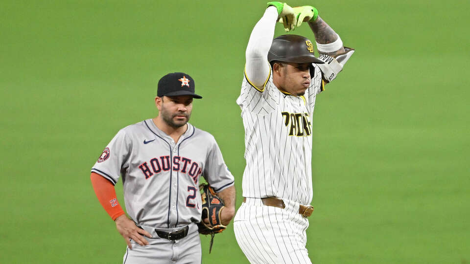 Manny Machado #13 of the San Diego Padres gestures after hitting an RBI double as Jose Altuve #27 of the Houston Astros looks on during the first inning of a baseball game September 16, 2024 at Petco Park in San Diego, California. (Photo by Denis Poroy/Getty Images)