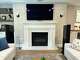 In this photo, Stephanie Salway, owner and creative director of Starlily Design Studio LLC, replicated grasscloth wallpaper with specialty paint finish on the fireplace wall in a living room.