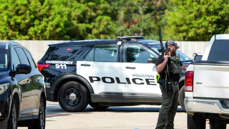 Police investigate the scene where a police officer was shot responding to an alleged home invasion, in the 7100 block of Alderney Drive on Tuesday, Sept. 17, 2024 in Houston. According to Houston Police Chief Noe Diaz, two men knocked on the door of a home and rushed in as soon as the homeowner opened it. A nearby neighbor immediately called 911. As officers approached the right side of the home, police said a suspect in a hoodie shot at one of the officers in his 'lower extremities.' The officer returned fire, Diaz said. The officer was transported to Memorial Hermann Hospital. Two suspects have been taken into custody.