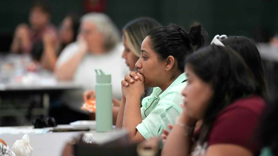 A woman listens to a presentation at Edison Middle School on Tuesday, Sept. 17, 2024, in Houston, as HISD held a town hall for community members on the proposal in the $4.4 billion school bond to co-locate Edison Middle School and Franklin Elementary Schools.