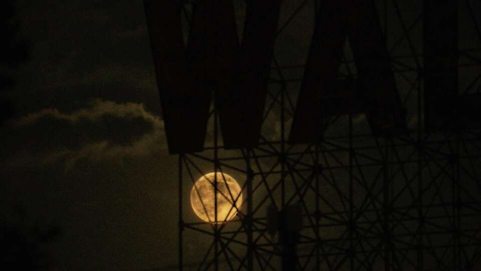 Tuesday night's full moon shown through the WADL sign in Eado neighborhood of Houston on Tuesday, Sept. 17, 2024. Tuesday night's full moon not just a full moon, but SuperMoon, a Harvest moon and a corn moon, that also featured a partial lunar eclipse.