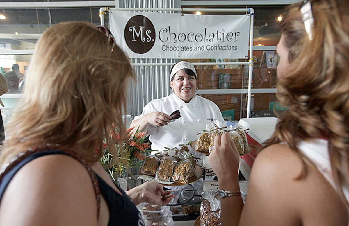 Janie Romo offers samples of her confections to potential customers. The owner of Ms. Chocolatier sells her chocolate treats at the Pearl Farmers Market and other places. She plans to open her own shop.