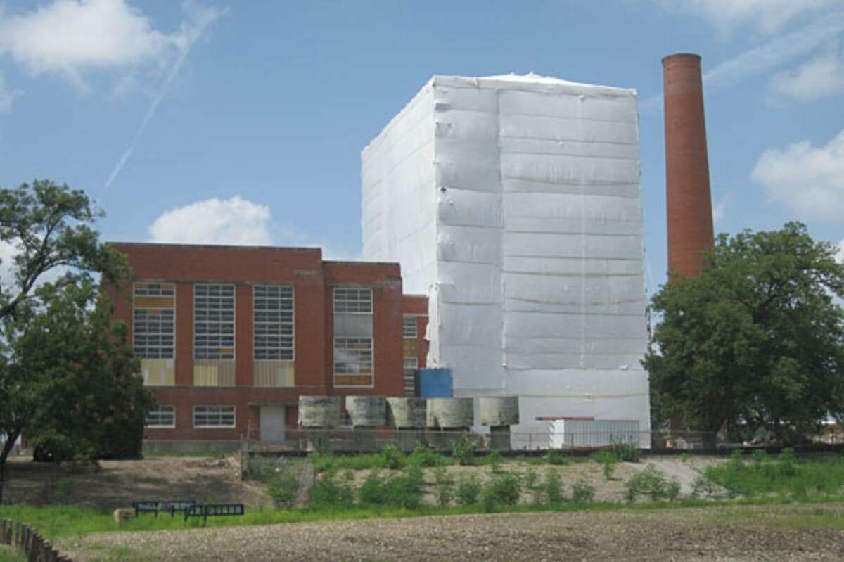 A giant white sheet hangs over part of Mission Road Power Plant as renovations are underway for what CPS Energy hopes will be a facility including condos, shops and parks. Th e sheet covers possible lead paint contamination as the building is shelled.