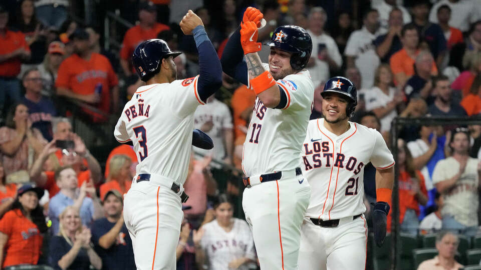 Houston Astros' Victor Caratini (17) celebrates with Jeremy Peña (3) after hitting a three-run home run during the third inning of an MLB baseball game at Minute Maid Park on Saturday, Sept. 21, 2024, in Houston.