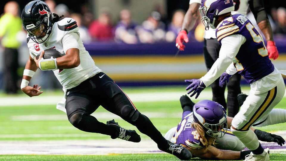 Houston Texans quarterback C.J. Stroud (7) is tripped up by Minnesota Vikings linebacker Andrew Van Ginkel (43) as he was forced to scramble out of the pocket during the first half of an NFL football game Sunday, Sept. 22, 2024, in Minneapolis, Minn.