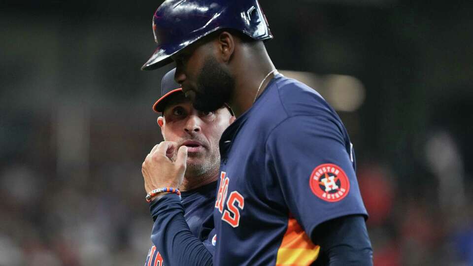 Houston Astros manager Joe Espada, left, talks with Yordan Alvarez after his comes out of the game after sliding into second base during the third inning of an MLB baseball game at Minute Maid Park, Sunday, Sept. 22, 2024, in Houston.