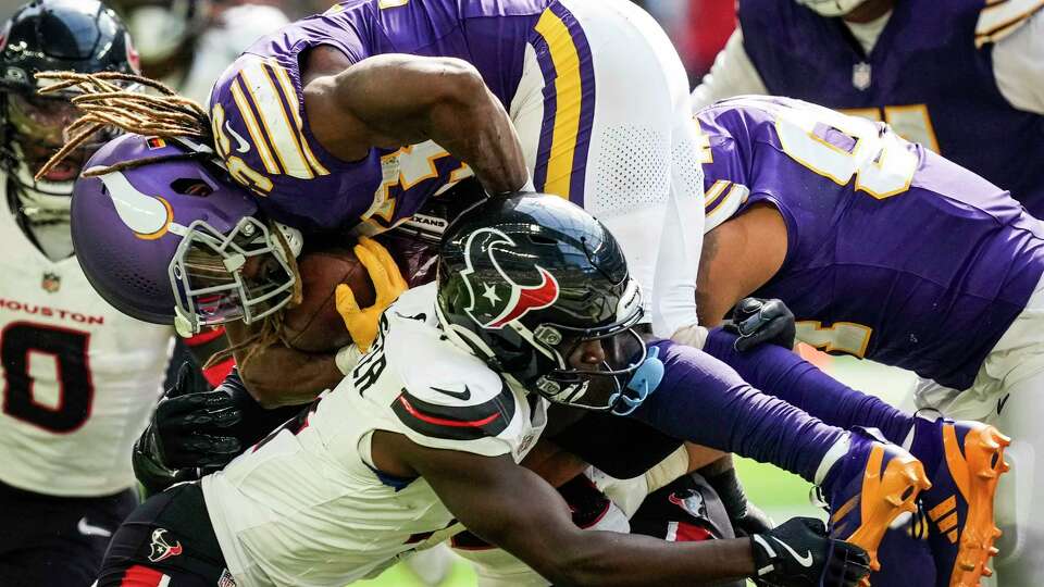 Houston Texans cornerback Kamari Lassiter (4) tackles Minnesota Vikings running back Aaron Jones (33) at the line of scrimmage during the first half of an NFL football game Sunday, Sept. 22, 2024, in Minneapolis, Minn.