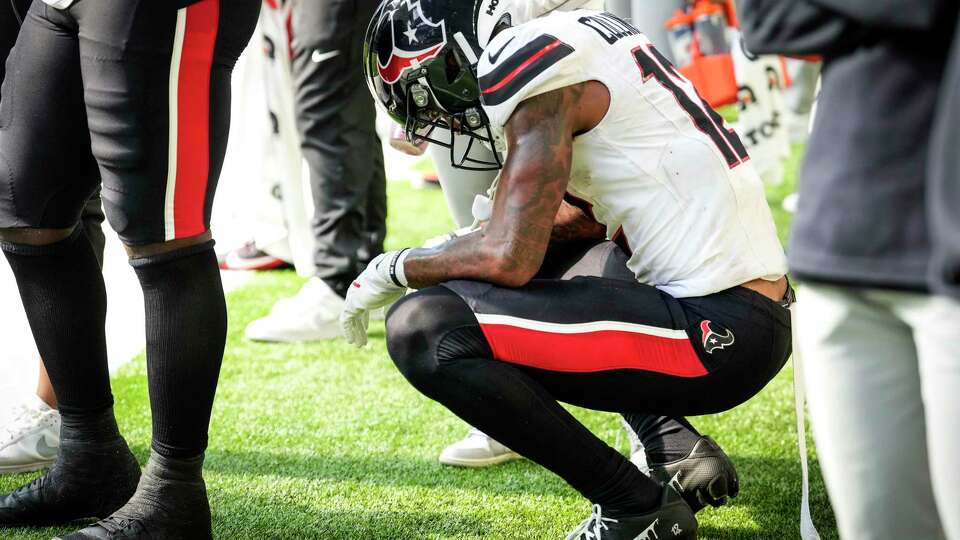 Houston Texans wide receiver Nico Collins (12) squats on the sidelines as time runs out during the second half of an NFL football game against the Minnesota Vikings Sunday, Sept. 22, 2024, in Minneapolis, Minn.