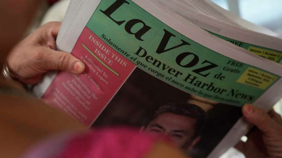 La Voz de Denver Harbor News distribution and volunteer Rita Rocha carries a stack of newspaper to restock at Matamoros Meat Market #1 Monday, Sept. 23, 2024 at Denvor Harbor in Houston. The group left 20 copies of the newspaper at the meat market less than a week ago, and it was all gone by the time they went to restock.