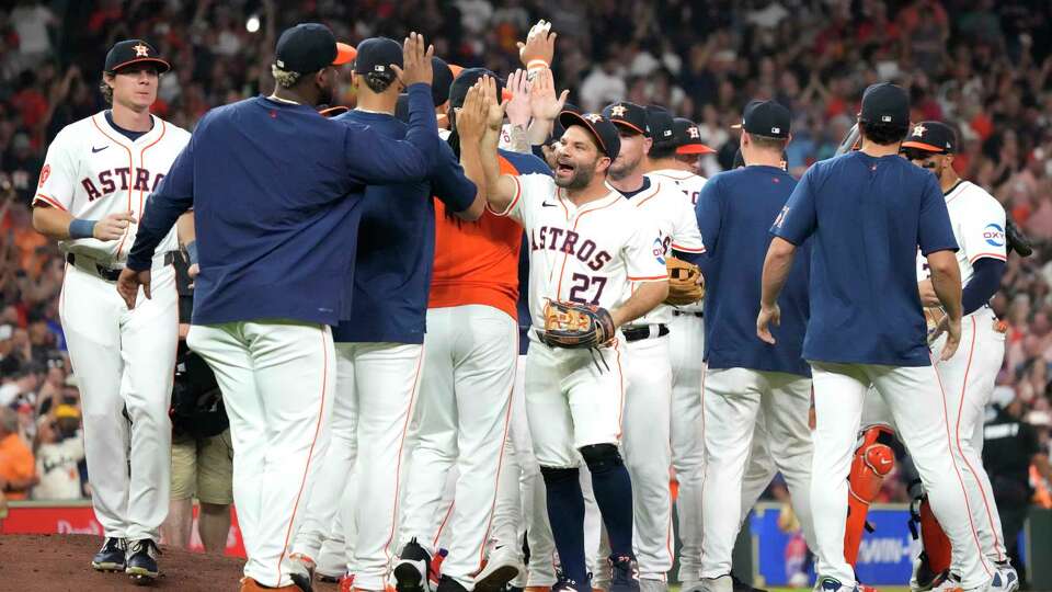 Houston Astros Jose Altuve (27) high fives Ronel Blanco as they celebrated after winning the American League West title after beating the Seattle Mariners 4-3 after an MLB baseball game at Minute Maid Park on Tuesday, Sept. 24, 2024, in Houston.