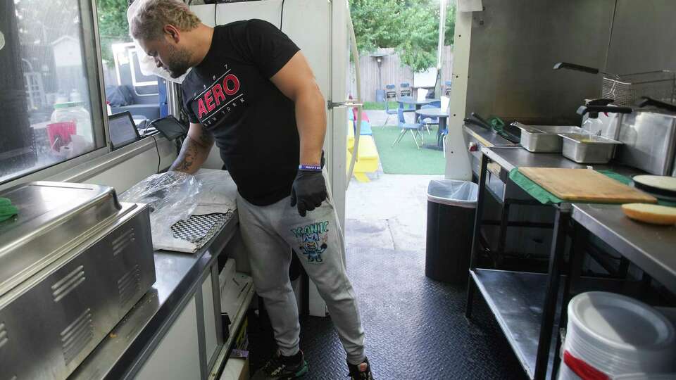 Eugenio Velazco checks on an order inside Don Pollo Burger food truck near World Theater on Tuesday, Sept. 24, 2024 in Katy. The established Venezuelan coming in Katy has changed in recent years with the increased of immigrants from the country.