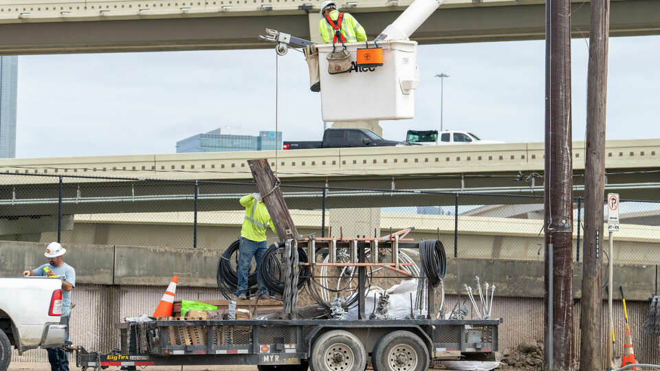 A utility line crew removes and replaces a wooden power pole with a composite pole along Westpark Drive near the IH-610 interchange Tuesday, Sep 10, 2024 in Houston.