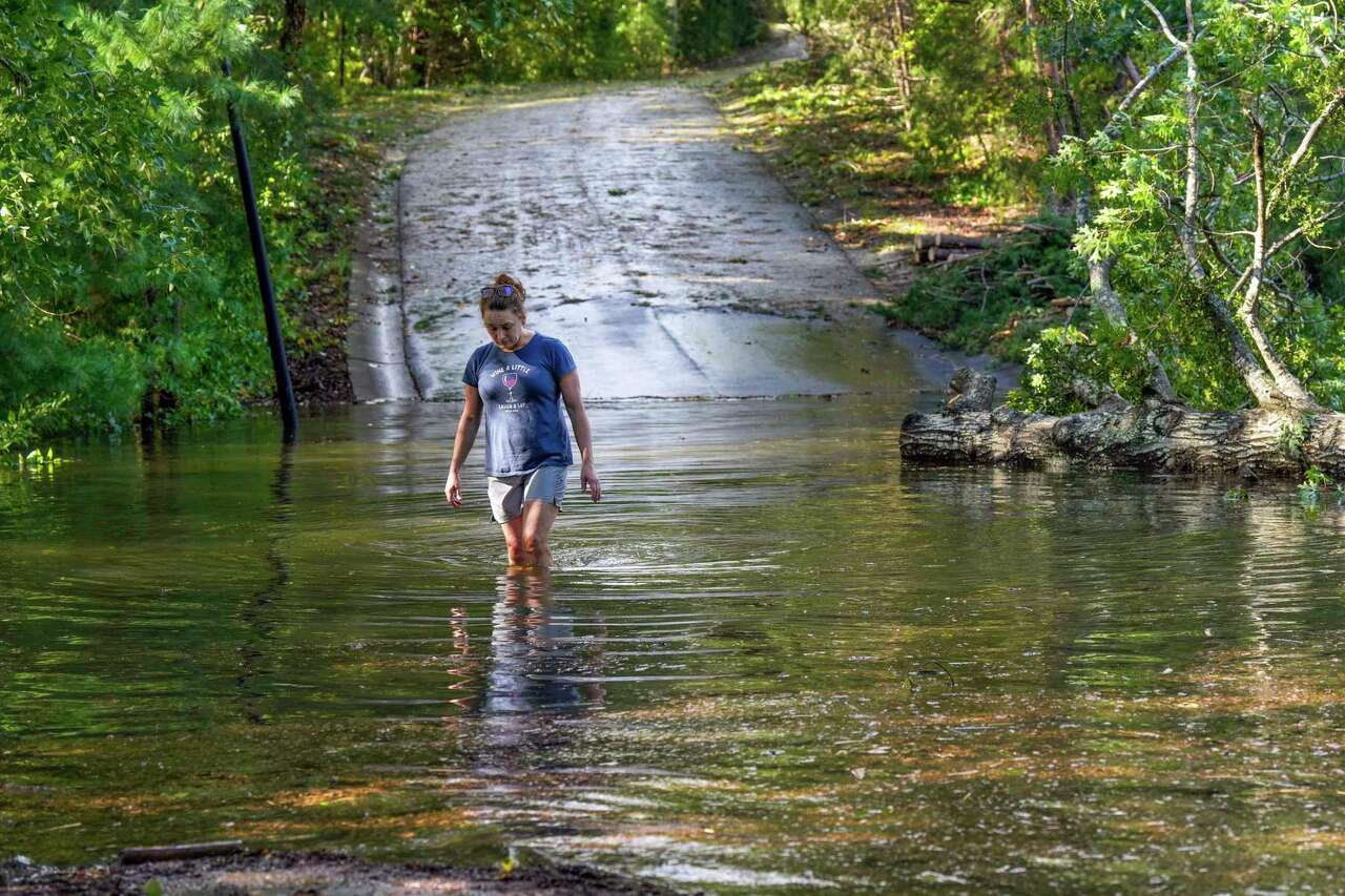 Teresa Elder walks through a flooded Sandy Cove Drive, from Hurricane Helene Friday, Sept. 27, 2024 in Morganton, N.C. (AP Photo/Kathy Kmonicek)