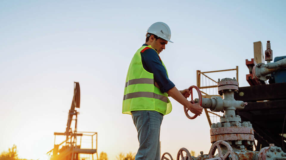 An oilfield worker pumping down lines.