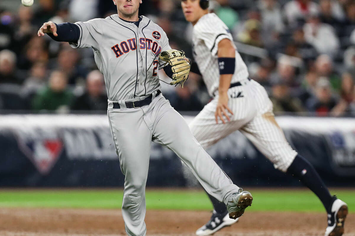 Houston Astros third baseman Alex Bregman (2) throws out New York Yankees catcher Gary Sanchez, as right fielder Aaron Judge runs past in the background, to end the third inning of Game 3 of the ALCS at Yankee Stadium on Monday, Oct. 16, 2017, in New York.