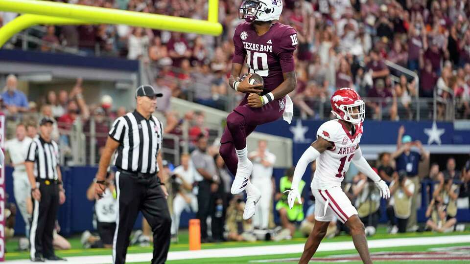 Texas A&M quarterback Marcel Reed (10) reacts in front of Arkansas defensive back Marquise Robinson (13) after scoring on a touchdown run during the first half of an NCAA college football game, Saturday, Sept. 28, 2024, in Arlington, Texas. (AP Photo/Julio Cortez)