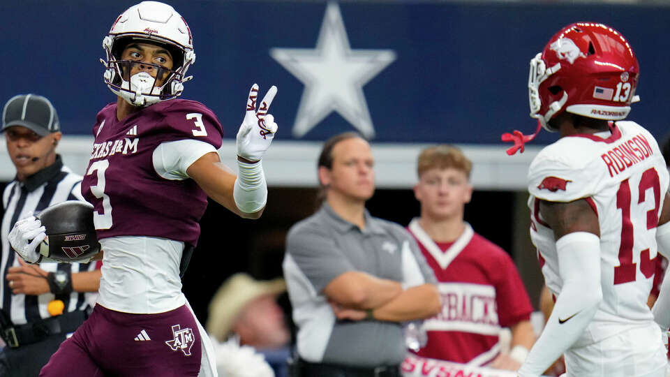 Texas A&M wide receiver Noah Thomas (3) gestures at Arkansas defensive back Marquise Robinson (13) while scoring on a long touchdown reception during the first half of an NCAA college football game, Saturday, Sept. 28, 2024, in Arlington, Texas. (AP Photo/Julio Cortez)