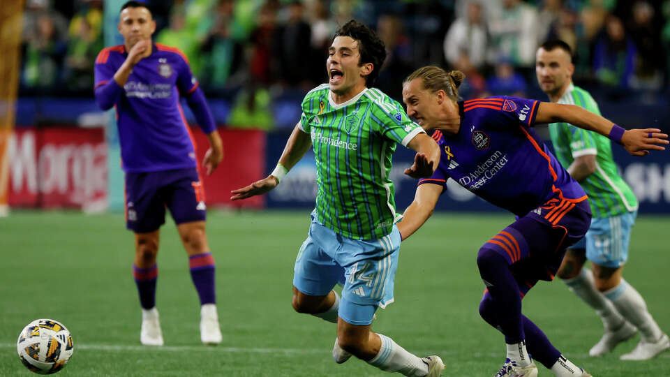 Houston Dynamo midfielder Griffin Dorsey clips Seattle Sounders FC midfielder Paul Rothrock to pick up a yellow card during the first half Saturday, Sept. 28, 2024 in Seattle. (Jennifer Buchanan/The Seattle Times via AP)