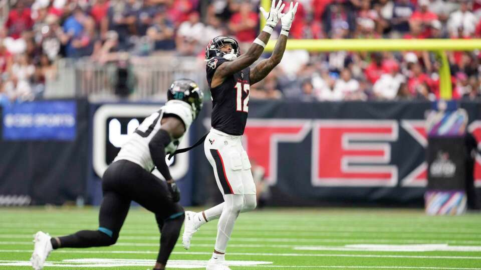 Houston Texans wide receiver Nico Collins (12) reaches up to make a catch against the Jacksonville Jaguars during the first half of an NFL football game Sunday, Sept. 29, 2024, in Houston.