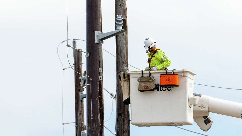 A utility line crew member replaces an older wooden power pole with a composite pole along Westpark Drive near the IH-610 interchange Tuesday, Sep 10, 2024 in Houston.