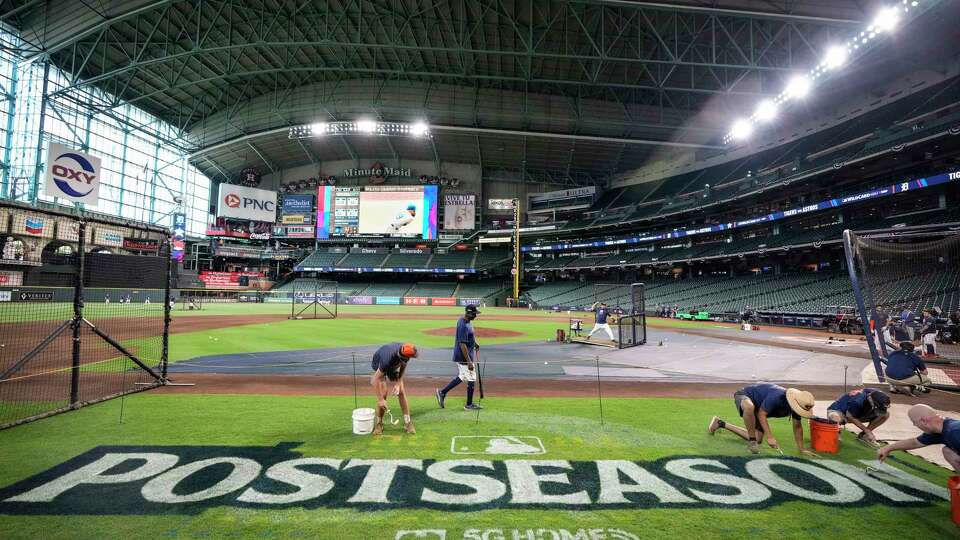 The grounds crew paint a postseason logo on the Minute Maid Park infield as the Houston Astros practice on the eve of an MLB wild-card series against the Detroit Tigers on Monday, Sept. 30, 2024, in Houston. The Astros face the Tigers in a best-of-three series.