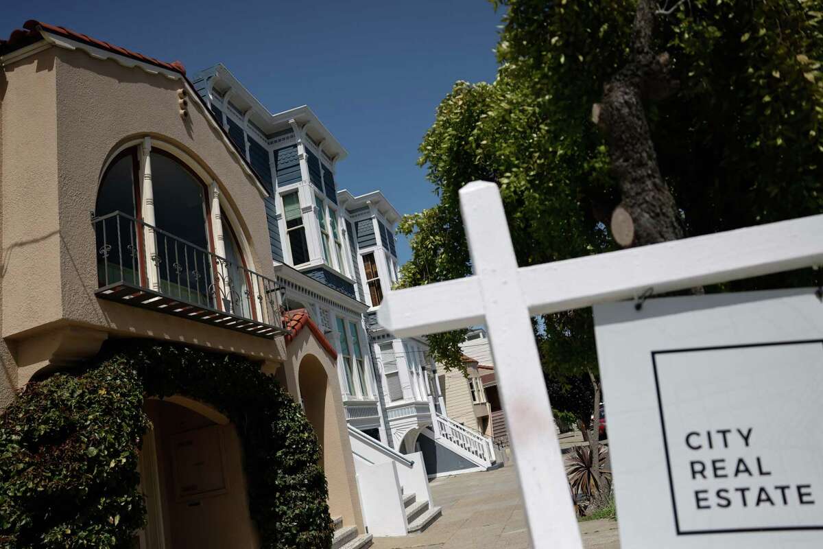 Homes are seen next to a realty company’s sign in front of home for sale on Wednesday, May 22, 2024 in San Francisco, Calif.