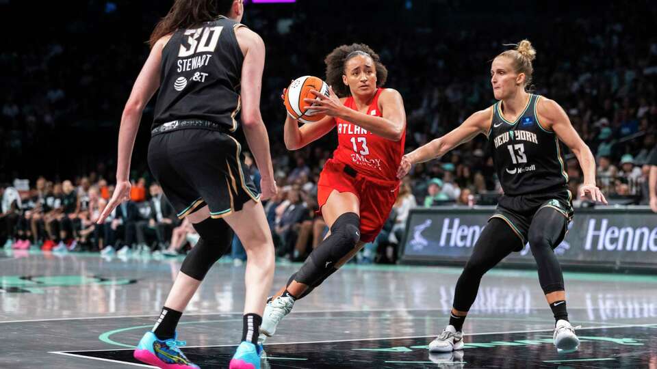 Atlanta Dream guard Haley Jones (13) drives between New York Liberty forward Breanna Stewart (30) and forward Leonie Fiebich (13) during the second half of a WNBA basketball first-round playoff game, Sunday, Sept. 22, 2024, in New York. (AP Photo/Corey Sipkin)