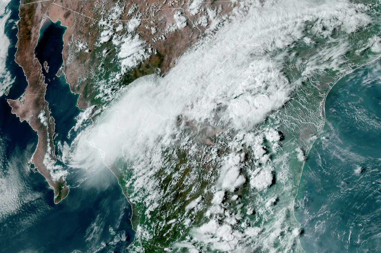 This satellite image provided by the U.S. National Oceanic and Atmospheric Administration shows Tropical Storm Ileana, left, near the coastal Mexican city of Topolobampo on the eastern side of the Gulf of California, on Sept. 14.