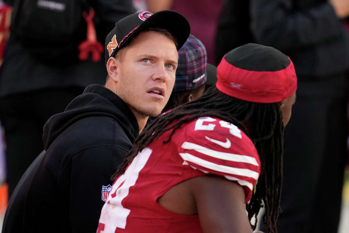 San Francisco 49ers running back Christian McCaffrey, left, sits on the sideline next to running back Jordan Mason during the second half of an NFL football game against the New England Patriots in Santa Clara, Calif., Sunday, Sept. 29, 2024.