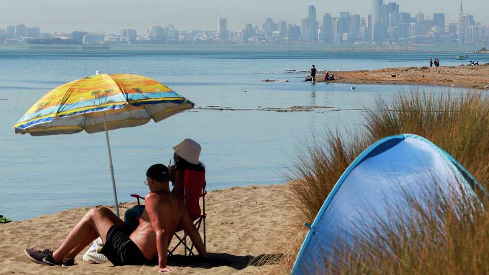 Residents lounge near the water on Alameda Beach in Alameda, California Wednesday, Oct. 2, 2024 during an exceptional heat wave across the Bay Area and inland.