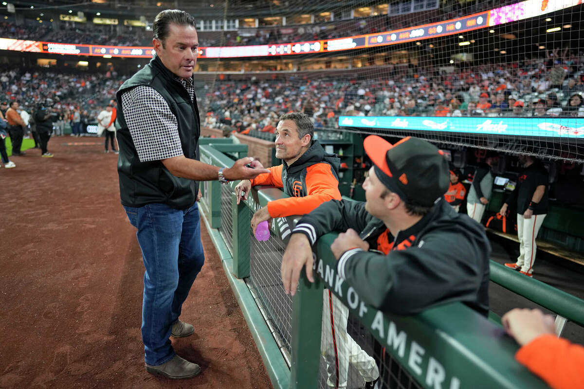 J.T. Snow (left), Pat Burrell (middle), and Casey Schmitt (right) of the San Francisco Giants talk before the game at Oracle Park on September 27, 2024 in San Francisco, California.