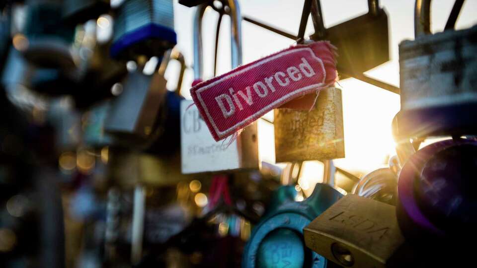 A love lock with a divorced label attached to it located at the pedestrian bridge over Allen Parkway, Wednesday, Aug. 15, 2018, in Houston.