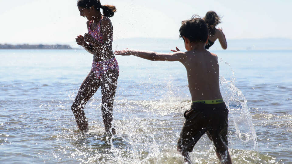 Kids splash each other while playing in the waters of Alameda Beach in Alameda, California Wednesday, Oct. 2, 2024 during an exceptional heat wave across the Bay Area and inland.