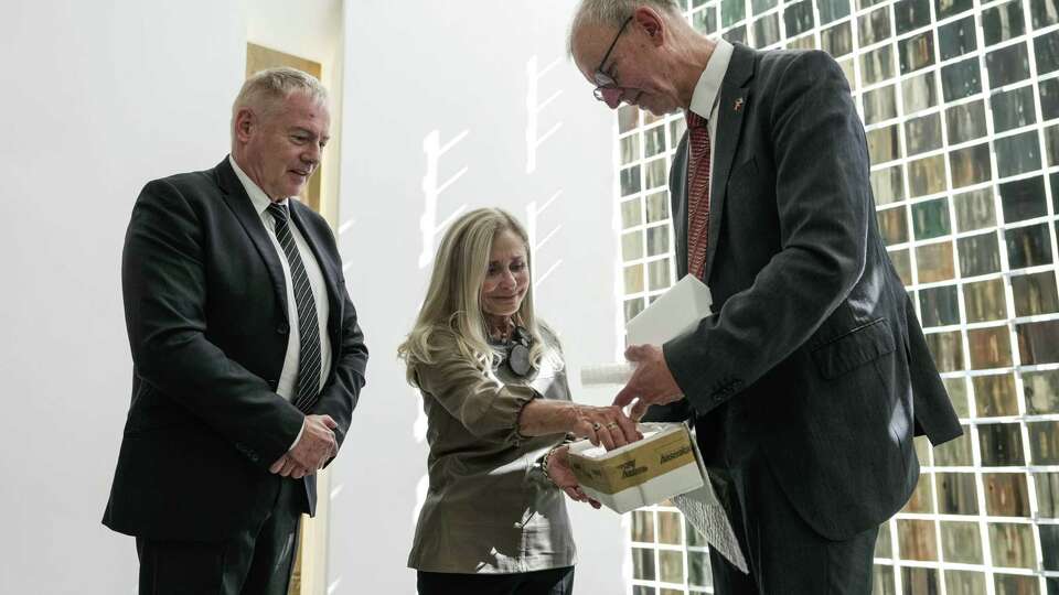 Consul General of Germany Kai Hennig joins Bavarian National Museum of Munich Curator Dr. Matthias Weniger in returning a silver serving dish after the piece was confiscated by the Nazis, to Holocaust survivor descendant, and 29-year Holocaust Museum Houston volunteer, Sandy Breisacher Lessig on Friday, Oct. 4, 2024 in Houston.