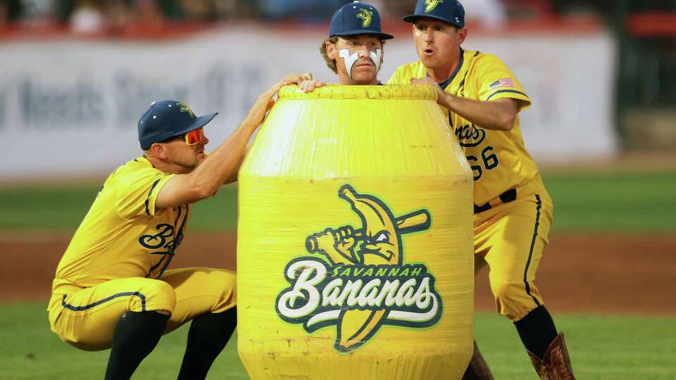 Savannah Bananas’ relief pitcher Mat Wolf peers out of a barrel during baseball game at Excite Ballpark in San Jose, Calif., on Tuesday, July 25, 2023.