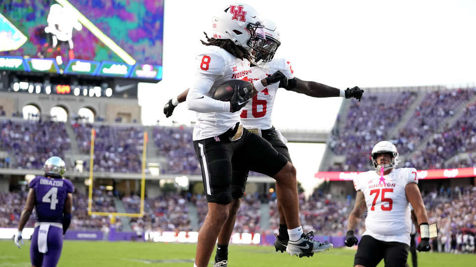 Houston's Devan Williams (8) and Re'Shaun Sanford II (26) celebrate Williams touchdown catch in the first half of an NCAA college football game against TCU, Friday, Oct. 4, 2024, in Fort Worth, Texas. (AP Photo/Tony Gutierrez)