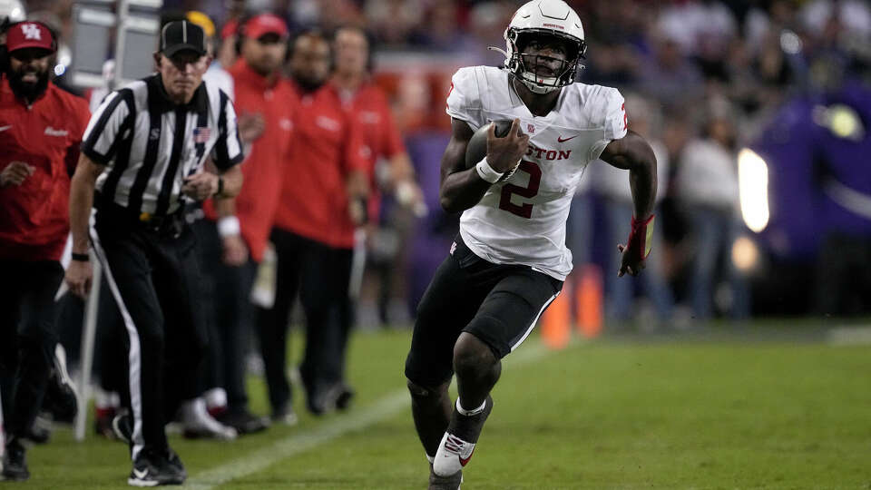 Houston quarterback Zeon Chriss, right, carries the ball for a long gain on a running play against TCU in the first half of an NCAA college football game Friday, Oct. 4, 2024, in Fort Worth, Texas. (AP Photo/Tony Gutierrez)