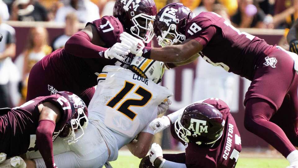 Missouri Tigers quarterback Brady Cook (12) is sacked by Texas A&M Aggies defensive lineman Nic Scourton (11) along with pressure by defensive lineman Albert Regis (17) and defensive lineman Cashius Howell (18) and linebacker Daymion Sanford (27) during the fourth quarter of a SEC conference college football game at Kyle Field, Saturday, Oct. 5, 2024, in College Station.