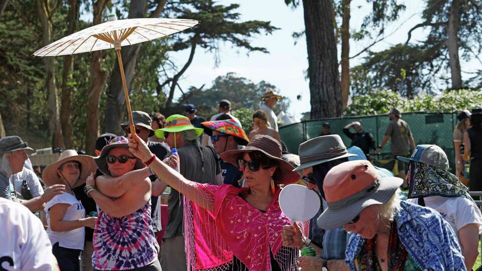 Festivalgoers take cover from the sun and cool down during the Hardly Strictly Bluegrass music festival at Golden Gate Park in San Francisco on Saturday, Oct. 05, 2024.