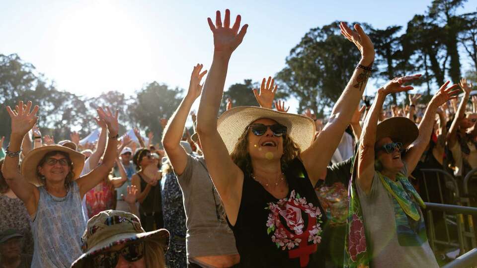 Fans of Patti Smith raise their hands at the end of a song during her set at Hardly Strictly Bluegrass festival at Golden Gate Park on Sunday, Oct. 6, 2024.