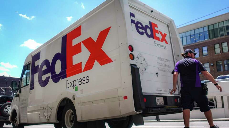 FILE - In this June 25, 2019, file photo, a FedEx delivery truck is loaded by an employee on the street in downtown Cincinnati. FedEx is off to a fast start during the holiday-shipping season. The company said Thursday, Dec. 17, 2020, that its quarterly profit more than doubled to $1.23 billion. Revenue is up 19%, led by growth in its ground business that handles packages. (AP Photo/John Minchillo, File)