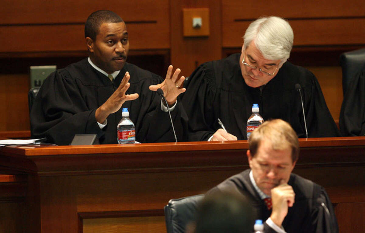 Justice Dale Wainwright (left) gestures during a hearing at St. Mary?s University School of Law as justices Nathan L. Hecht (right) and Don R. Willett (front) listen.