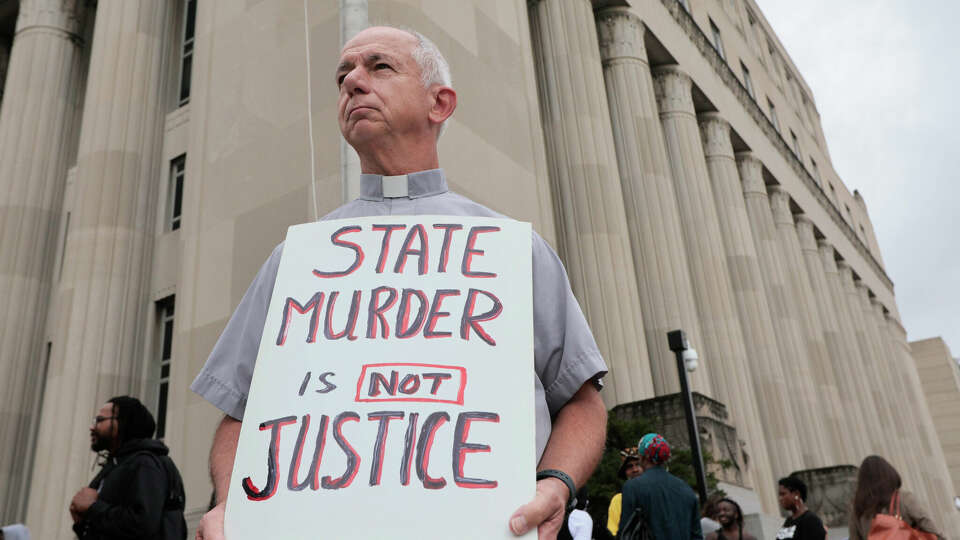 Deacon Dave Billips, with the Office of Peace and Justice with the St. Louis Archdiocese, holds a sign as he stands with protesters holding space to halt the execution of Marcellus Williams on Tuesday, Sept. 24, 2024, outside the Carnahan Courthouse in St. Louis. 