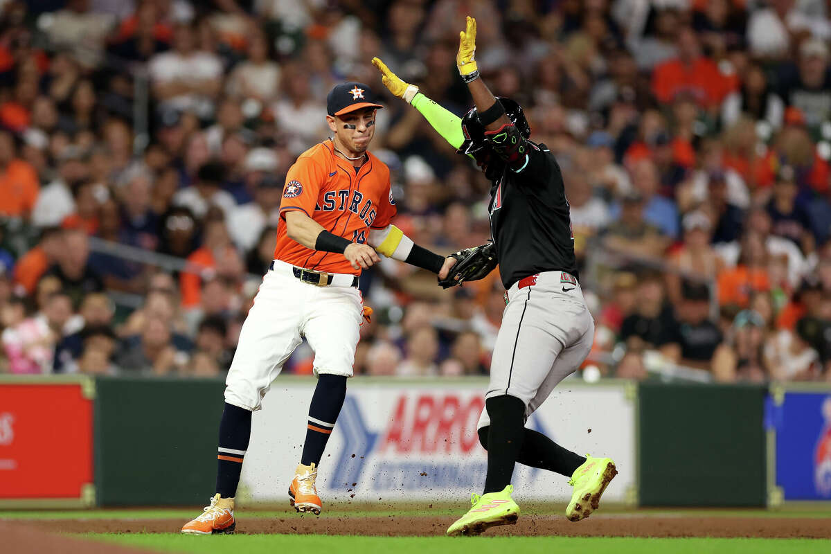 HOUSTON, TEXAS - SEPTEMBER 06: Mauricio Dubon #14 of the Houston Astros tags Geraldo Perdomo #2 of the Arizona Diamondbacks out in the third inning at Minute Maid Park on September 06, 2024 in Houston, Texas. (Photo by Tim Warner/Getty Images)