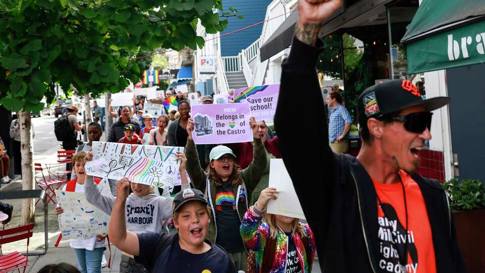 Harvey Milk Civil Rights Academy Physical Education teacher Derek Dulin, right, leads students, faculty and parents of Harvey Milk Civil Rights Academy as they march down Castro Street to Harvey Milk Plaza in San Francisco, Calif. Wednesday, October 9, 2024 to protest the closure of the school along with 10 others in San Francisco