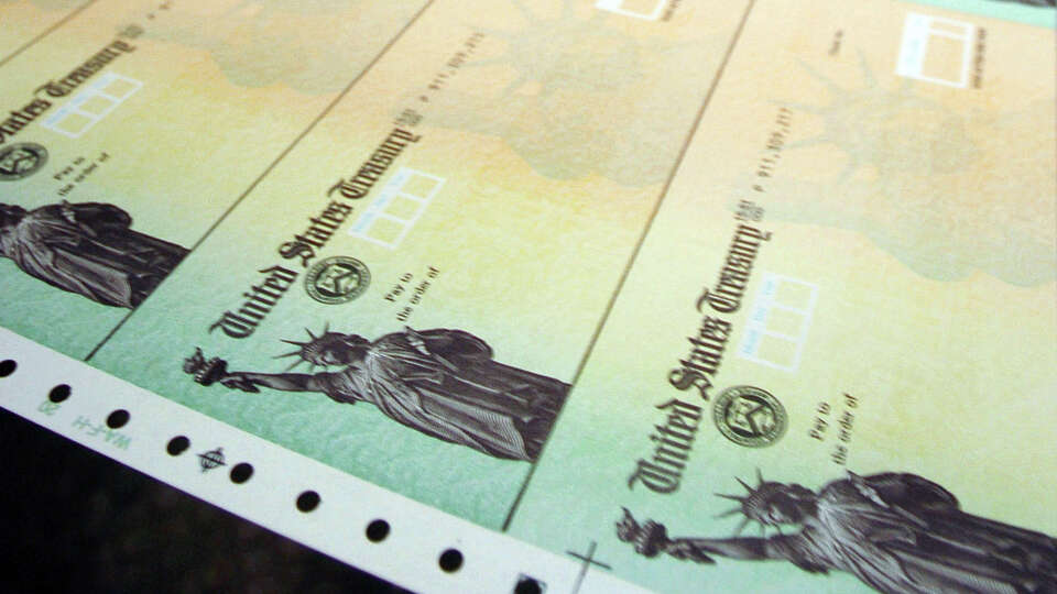 In this Feb. 11, 2005, file photo rolls of blank social security checks run through printers and are processed at the U.S. Treasury's Financial Management services facility in Philadelphia. Social Security recipients shouldn't expect a big increase in monthly benefits come January. Preliminary figures show the annual benefit boost will be between 1 percent and 2 percent, which would be among the lowest since automatic adjustments were adopted in 1975. (AP Photo/Bradley C Bower, file)