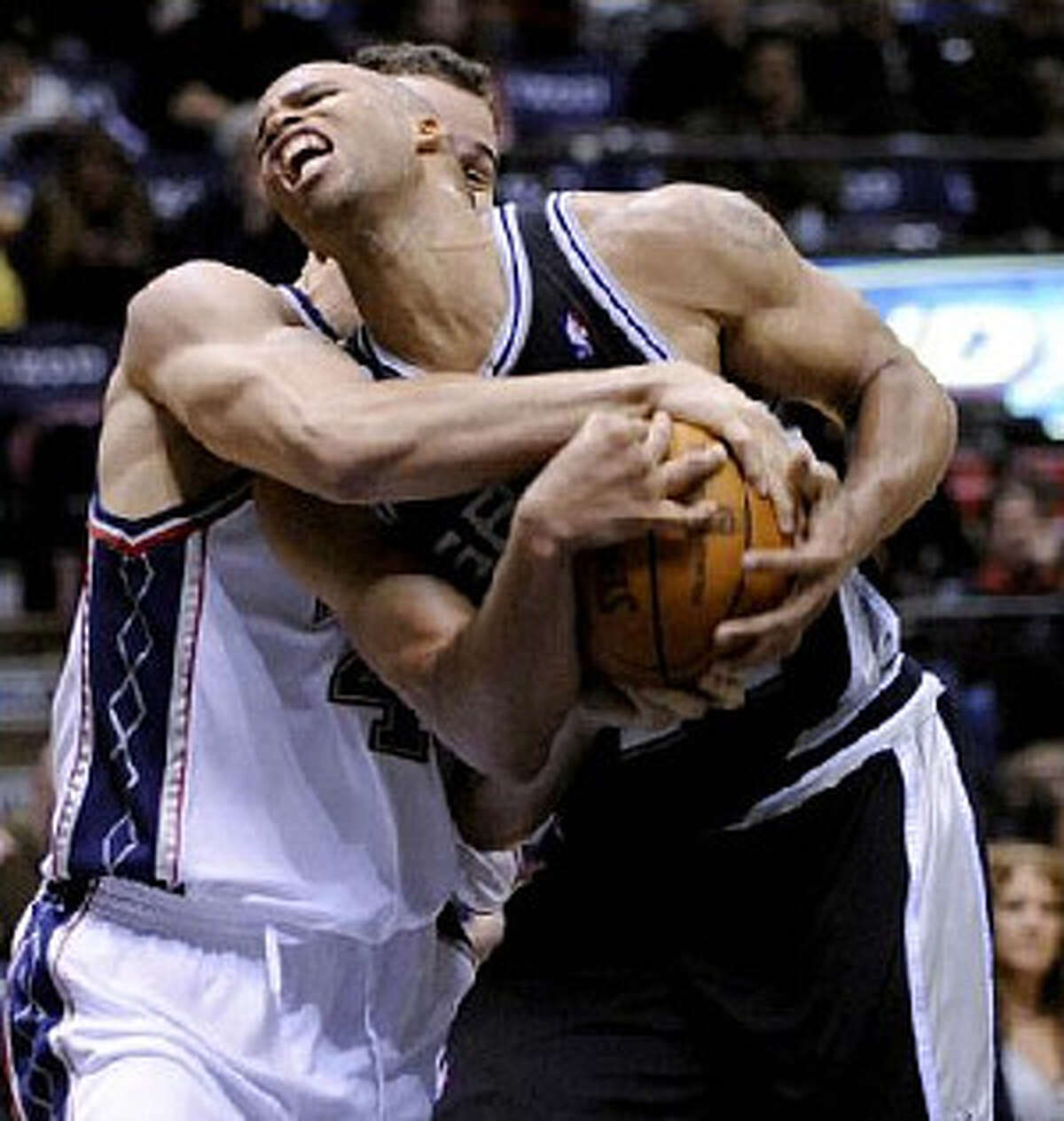 The Nets' Kris Humphries (left) ties up the Spurs' Richard Jefferson while on his way to the basket during New Jersey's 10th victory.