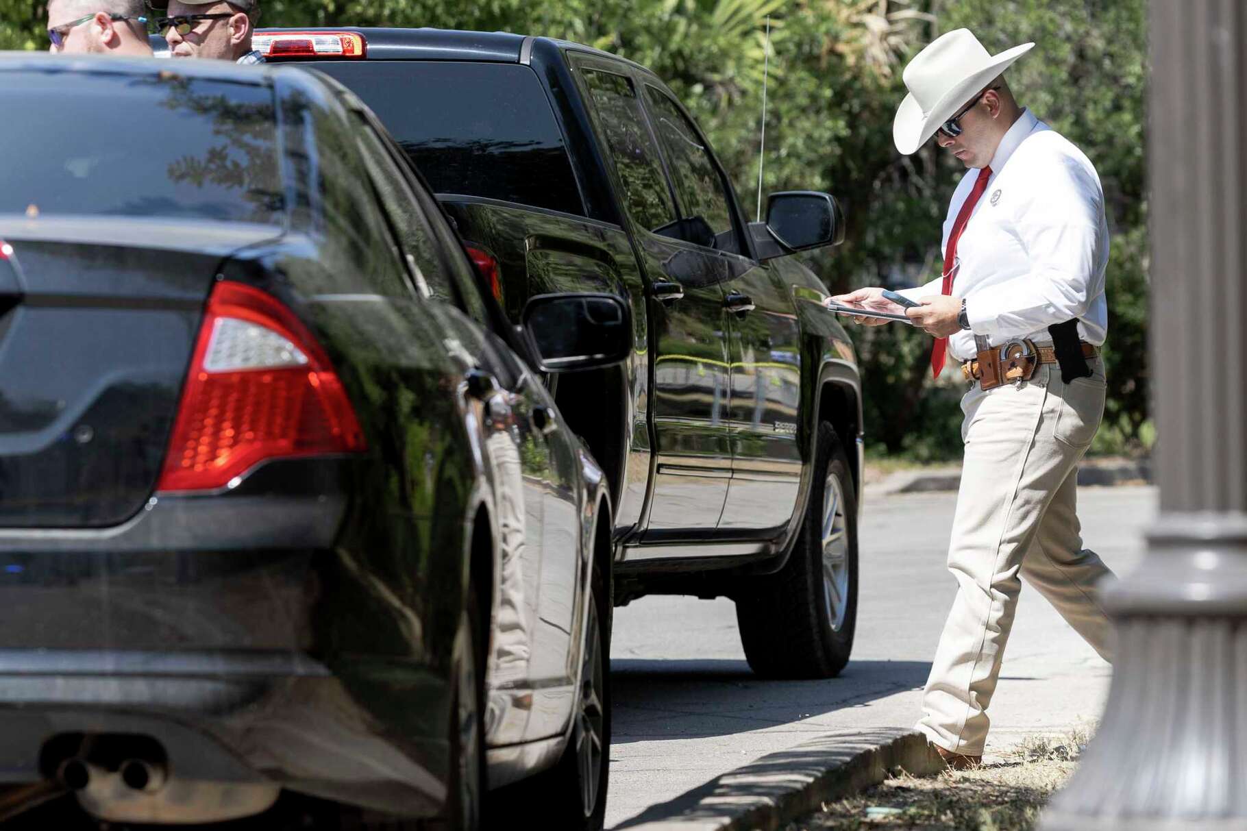 A Texas Ranger looks at a tablet while working on the investigation into the disappearance of Suzanne Clark Simpson on Thursday, Oct. 10, 2024, in Olmos Park, Texas.