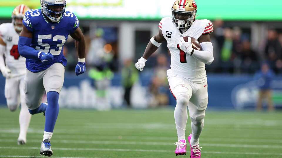 SEATTLE, WASHINGTON - OCTOBER 10: Deebo Samuel Sr. #1 of the San Francisco 49ers runs the ball for a touchdown ahead of Boye Mafe #53 of the Seattle Seahawks during the second quarter at Lumen Field on October 10, 2024 in Seattle, Washington.